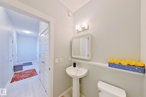 Pedestal sink with wall-mounted medicine cabinet and overhead vanity light fixture - 1221 27 Street, Edmonton, AB - Indoor Photo Showing Bathroom