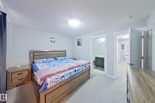 Carpeted bedroom with light-colored walls and a ceiling-mounted light fixture - 1221 27 Street, Edmonton, AB - Indoor Photo Showing Bedroom