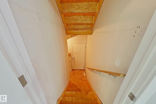 Unfinished stairwell featuring plywood treads, a natural wood handrail, and drywall walls - 1221 27 Street, Edmonton, AB - Indoor Photo Showing Other Room