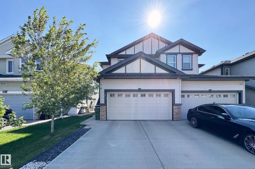 Two-story residence featuring light-colored siding with dark trim accents - 1221 27 Street, Edmonton, AB - Outdoor