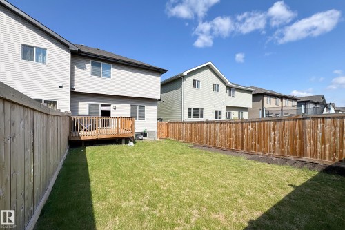 Expansive grassy yard featuring a wood privacy fence and a rear deck with wood railing - 1221 27 Street, Edmonton, AB - Outdoor With Deck Patio Veranda With Exterior