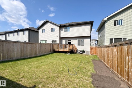 Expansive backyard featuring a wood deck with stairs, a manicured lawn area, and natural wood fencing - 1221 27 Street, Edmonton, AB - Outdoor With Exterior