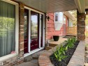 Brick facade with a deep red entry door and sidelights - 12137 50 Street, Edmonton, AB  - Outdoor With Deck Patio Veranda With Exterior 