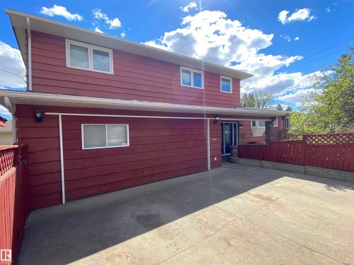Red-sided structure featuring an integrated carport and a concrete driveway - 12137 50 Street, Edmonton, AB - Outdoor With Exterior
