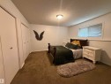 Carpeted room with a ceiling-mounted light fixture, white walls, and a window with blinds - 1875 Mill Woods Road E, Edmonton, AB  - Indoor Photo Showing Other Room 