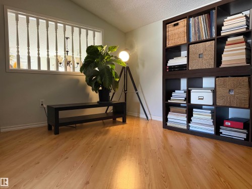 Light wood-finish flooring complements the neutral wall color - 1875 Mill Woods Road E, Edmonton, AB - Indoor Photo Showing Other Room