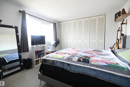 The master bedroom easily supports king sized furniture, thanks to it's generous floor space.  The full wall of floor to ceiling closets is a nice touch, and provides ample storage - 5823 Riverbend Road, Edmonton, AB - Indoor Photo Showing Bedroom