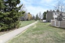 The front of this unit steps out into this open green space with a paved trail, that forms a part of the Brander Gardens off leash park area.  Perfect for outdoor family fun - 5823 Riverbend Road, Edmonton, AB  - Outdoor 