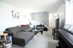 The open railings that lead upstairs to the bedroom level give an open feel to the large living room, with great furniture placement options.  The kitchen and large dining area are just around the corner to the right - 