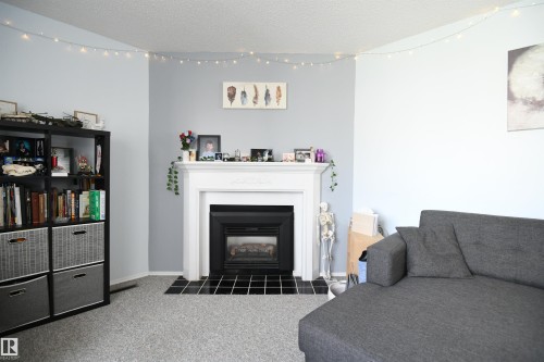 The gas fireplace is a very nice touch, and gives the living room a very warm and inviting feel - 5823 Riverbend Road, Edmonton, AB - Indoor Photo Showing Living Room With Fireplace