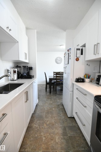 Recent renovations to both bathrooms in the home, as well as the kitchen, are standouts here.  White shaker cabinetry, solid surface counters, undermount sink, tile backsplash, a full sized pantry and more - 5823 Riverbend Road, Edmonton, AB - Indoor Photo Showing Kitchen
