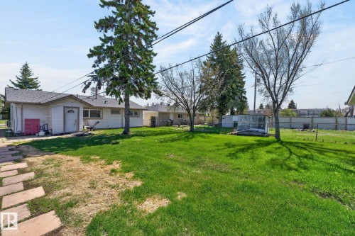 Spacious backyard featuring a substantial lawn, mature trees, and a stone paver pathway - 13412 108 Street, Edmonton, AB - Outdoor