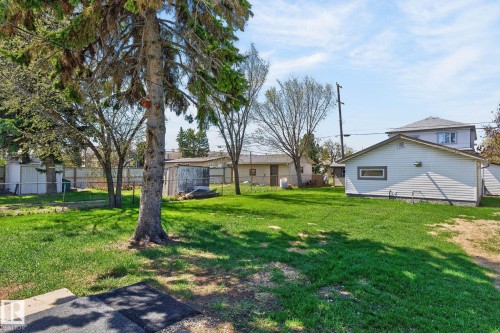 Spacious backyard with a detached garage featuring horizontal siding and a rectangular window - 13412 108 Street, Edmonton, AB - Outdoor