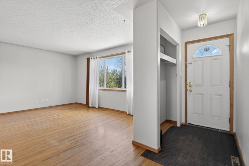 Bright entryway featuring a paneled door with an arched glass insert, recessed coat storage, and a flush-mount ceiling light - 13412 108 Street, Edmonton, AB - Indoor Photo Showing Other Room