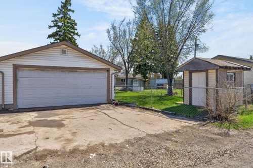 Detached garage with a double overhead door, vinyl siding, and an asphalt driveway - 13412 108 Street, Edmonton, AB - Outdoor