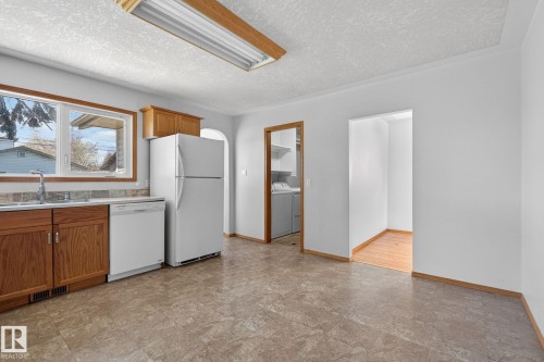Kitchen featuring wood cabinetry, white appliances, and a window above the sink - 13412 108 Street, Edmonton, AB - Indoor Photo Showing Kitchen With Double Sink