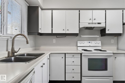 Kitchen featuring white cabinetry and countertops - 18 17409 95 Street, Edmonton, AB - Indoor Photo Showing Kitchen With Double Sink
