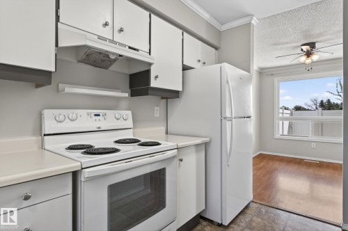 Kitchen featuring white cabinetry, a white electric range, and a white refrigerator - 18 17409 95 Street, Edmonton, AB - Indoor Photo Showing Kitchen
