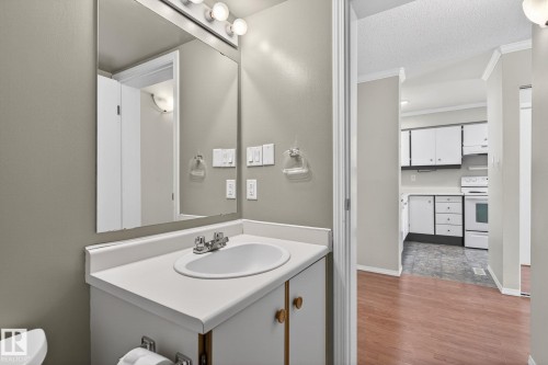 Bathroom vanity with an integrated sink, polished chrome faucet, and overhead lighting - 18 17409 95 Street, Edmonton, AB - Indoor Photo Showing Bathroom