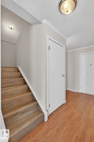 Wood-finish flooring throughout the entry, contrasting with light gray walls - 18 17409 95 Street, Edmonton, AB - Indoor Photo Showing Other Room