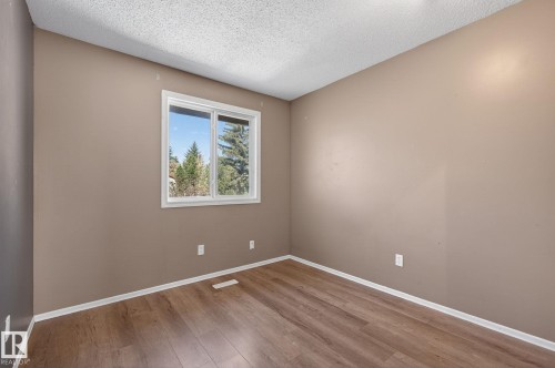 Room featuring wood-finish flooring, neutral wall paint, and white trim - 18 17409 95 Street, Edmonton, AB - Indoor Photo Showing Other Room