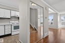 Entryway featuring mirrored closet doors, wood-finish flooring, and a stairway with wood treads - 18 17409 95 Street, Edmonton, AB  - Indoor Photo Showing Kitchen 