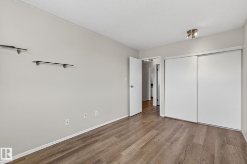 Bedroom featuring wood-finish flooring, light neutral wall tones, and a track light fixture - 18 17409 95 Street, Edmonton, AB - Indoor Photo Showing Other Room