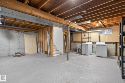 Unfinished basement offering exposed wood ceiling joists, concrete flooring, and a dedicated laundry area with utility sink - 18 17409 95 Street, Edmonton, AB - Indoor Photo Showing Basement