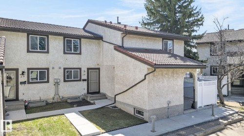 Two-story stucco townhome featuring a terracotta-style tile roof and brown trim - 18 17409 95 Street, Edmonton, AB - Outdoor With Exterior