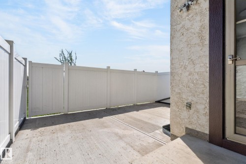 Private concrete patio area with white panel fencing - 18 17409 95 Street, Edmonton, AB - Outdoor