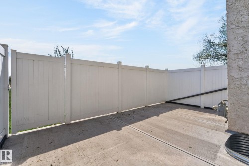 Private outdoor space featuring a concrete patio and a white privacy fence - 18 17409 95 Street, Edmonton, AB - Outdoor