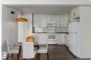 Updated Kitchen and dining area featuring amble  cabinetry, subway tile backsplash & full size appliances, including a dishwasher, fridge, stove & microwave hood fan. - 101 8604 Gateway Boulevard, Edmonton, AB  - Indoor Photo Showing Kitchen 