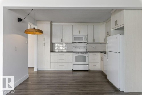 Updated Kitchen and dining area featuring amble  cabinetry, subway tile backsplash & full size appliances, including a dishwasher, fridge, stove & microwave hood fan. - 101 8604 Gateway Boulevard, Edmonton, AB - Indoor Photo Showing Kitchen