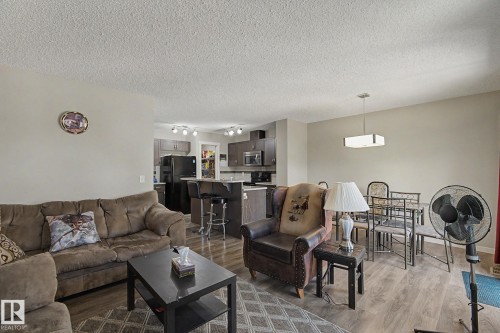 Open-concept living space featuring wood-finish flooring, neutral wall tones, and recessed lighting in the kitchen - 1211 29 Street, Edmonton, AB - Indoor Photo Showing Living Room