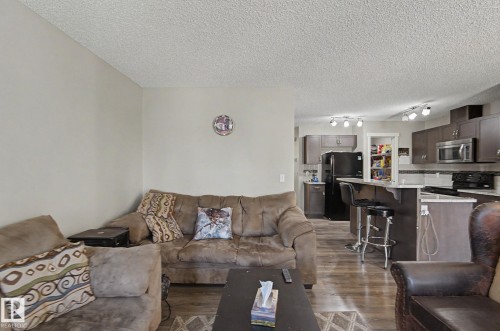 Open-concept living area with wood-finish flooring extending into the kitchen - 1211 29 Street, Edmonton, AB - Indoor Photo Showing Living Room