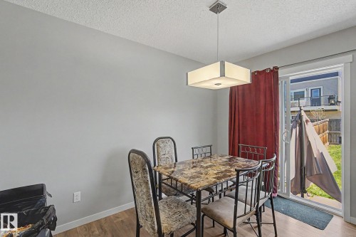 Dining area featuring light gray walls, wood-finish flooring, and a modern rectangular ceiling light fixture - 1211 29 Street, Edmonton, AB - Indoor Photo Showing Dining Room