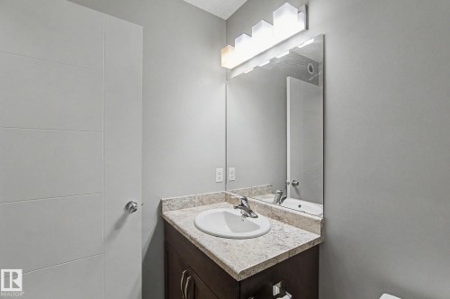 Bathroom vanity featuring a speckled countertop with an integrated sink and chrome faucet - 1211 29 Street, Edmonton, AB - Indoor Photo Showing Bathroom