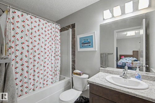 Bathroom featuring a white tub and shower combination with brown tile surround - 1211 29 Street, Edmonton, AB - Indoor Photo Showing Bathroom