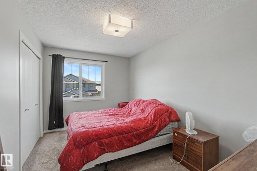 Bright room featuring a window with exterior views, light gray wall paint, textured ceiling, and a flush mount ceiling light - 1211 29 Street, Edmonton, AB - Indoor Photo Showing Bedroom