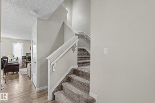 Carpeted staircase featuring white handrails and risers - 1211 29 Street, Edmonton, AB - Indoor Photo Showing Other Room