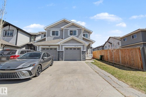 Modern two-story duplex featuring gray siding and stone accents - 1211 29 Street, Edmonton, AB - Outdoor