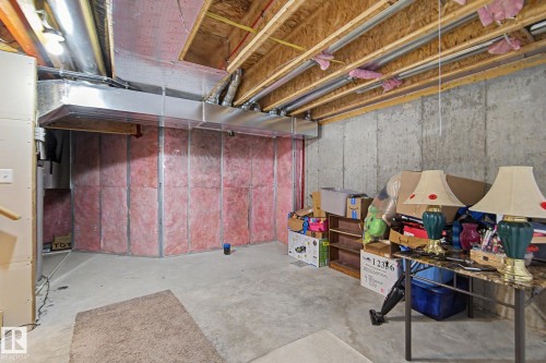 Unfinished basement space featuring exposed concrete walls, visible insulation, and open ceiling joists - 1211 29 Street, Edmonton, AB - Indoor Photo Showing Basement