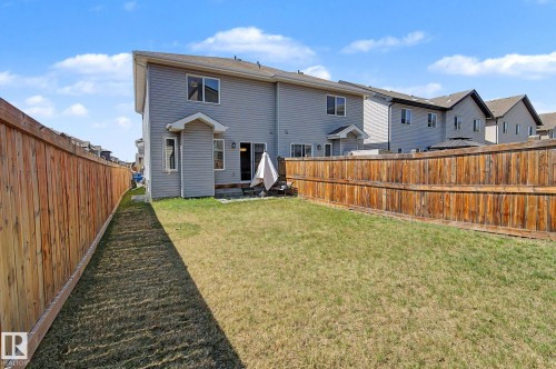 Expansive backyard featuring a manicured lawn, full privacy fencing, and a ground-level patio with direct home access - 1211 29 Street, Edmonton, AB - Outdoor