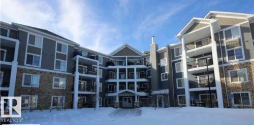 This building features a multi-story design with prominent balconies and a stone facade on the lower levels - 313 6084 Stanton Drive, Edmonton, AB - Outdoor With Balcony With Facade