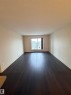 The main living area features dark wood flooring, light-colored walls, and a window providing natural light - 313 6084 Stanton Drive, Edmonton, AB  - Indoor Photo Showing Other Room 