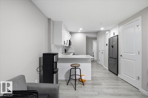 Contemporary kitchen featuring white cabinetry, a white countertop, and light wood-finish flooring - 7056 182 Avenue, Edmonton, AB - Indoor