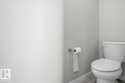 White toilet with a standard flush mechanism - 7056 182 Avenue, Edmonton, AB - Indoor Photo Showing Bathroom