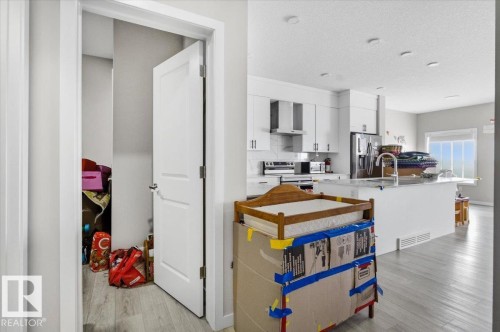 Modern kitchen with white cabinetry and stainless steel appliances - 7056 182 Avenue, Edmonton, AB - Indoor Photo Showing Kitchen