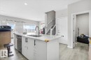 Kitchen island featuring a double-basin sink, gooseneck faucet, and integrated dishwasher - 7056 182 Avenue, Edmonton, AB  - Indoor Photo Showing Kitchen With Double Sink 