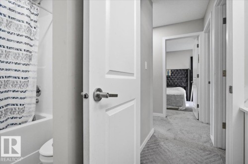 Hallway featuring light gray carpeting, white trim, and white paneled doors - 7056 182 Avenue, Edmonton, AB - Indoor Photo Showing Other Room